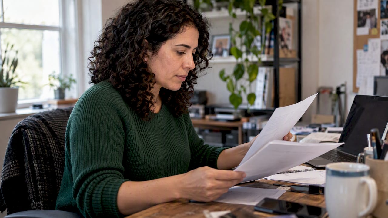 Woman comparing health plan costs at home